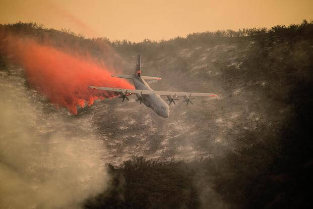A U.S. Air National Guard C-130J Hercules aircraft equipped with the MAFFS 2 drops a line of fire retardant on the Thomas Fire in the hills above the city of Santa Barbara, California, Dec. 13, 2017. (U.S. Air National Guard/Staff Sgt. Nieko Carzis)