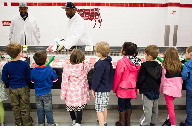 Damian Lofton, work leader, shows children from Cody Child Development Center's Robins B class of 4-to 5-year-olds packaged ground beef during a tour of Joint Base Myer-Henderson Hall's commissary. (U.S. Army/Rachel Larue)