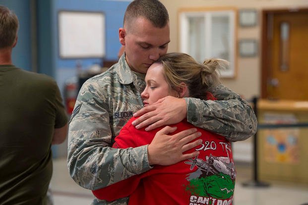 Senior Airman Nathan Slocum says his final goodbyes to a family member before deploying in support of Operation Freedom’s Sentinel. (U.S. Air National Guard/Adam Juchniewicz)