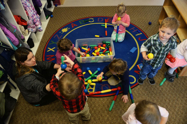Crystal Emmons, a program technician at the McRaven Child Development Center, plays with the children in her classroom at Ellsworth Air Force Base, South Dakota. (U.S. Air Force/Thomas Karol)