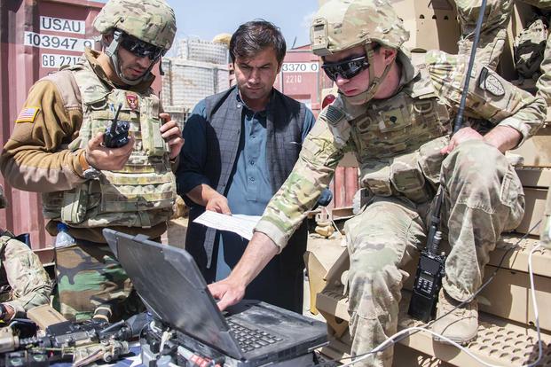 Spc. Stephen Powers, right, a communications adviser with Combat Adviser Team 1131, uses the Afghan National Tracking System to show his counterparts where Afghan soldiers are located during a clearing operation near Kabul, Afghanistan, on Sept. 16, 2018. (U.S. Army photo by Sean Kimmons)