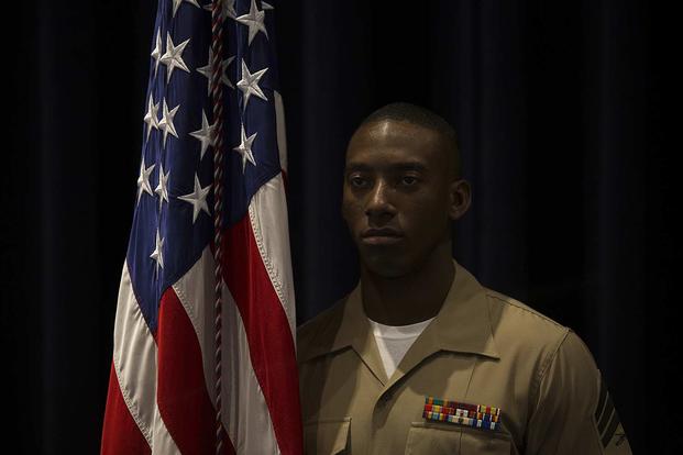 The 38th Color Sergeant of the Marine Corps, Sgt. Francis Frazier, poses for a photo next to the National Ensign at the conclusion of a relief and appointment ceremony at Marine Barracks Washington D.C., on April 6, 2018. (U.S. Marine Corps photo by Pfc. James Bourgeois)