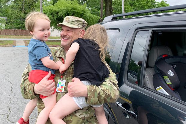 Maj. Russel Tart spends a moment during his lunch break to hug his grandchildren April 23, 2020