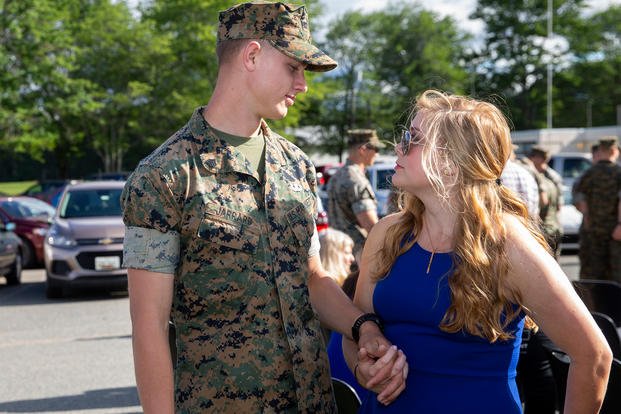 A U.S. Marine holds hands with his spouse.