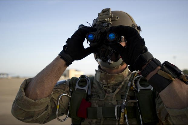 Green Beret prepares goggles for parachute jump