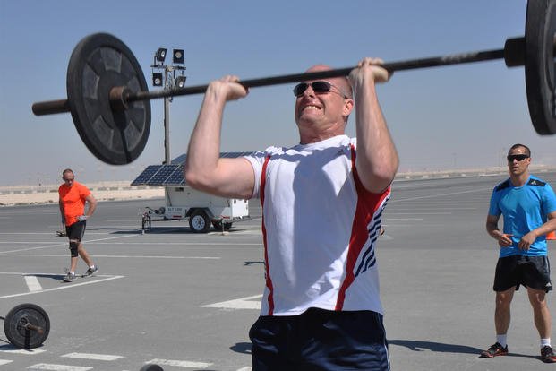 A wing commander performs push presses at Al Udeid Air Base, Qatar.