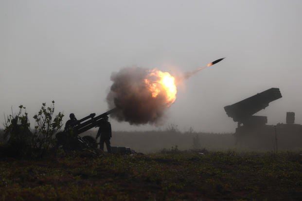 Indonesian Marines fire an artillery round during an amphibious landing operation.