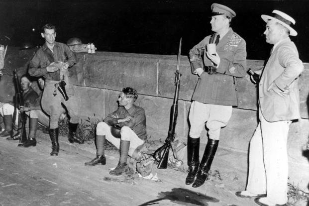 Chief of Staff Douglas MacArthur, standing against a bridge wall with a cup of coffee, rests with troops during a break in the Army's drive to evacuate war veterans camped out in Washington, D.C., in 1932. (AP Photo) Chief of Staff Douglas MacArthur, standing against a bridge wall with a cup of coffee, rests with troops during a break in the Army's drive to evacuate war veterans camped out in Washington, D.C., in 1932.
