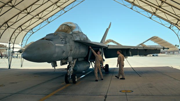Student Lt. Junior Grade Andrew Seepe, left, gets up close to his dream jet, the F-18. (Photo courtesy of National Geographic) Student Lt. Junior Grade Andrew Seepe, left, gets up close to his dream jet, the F-18.
