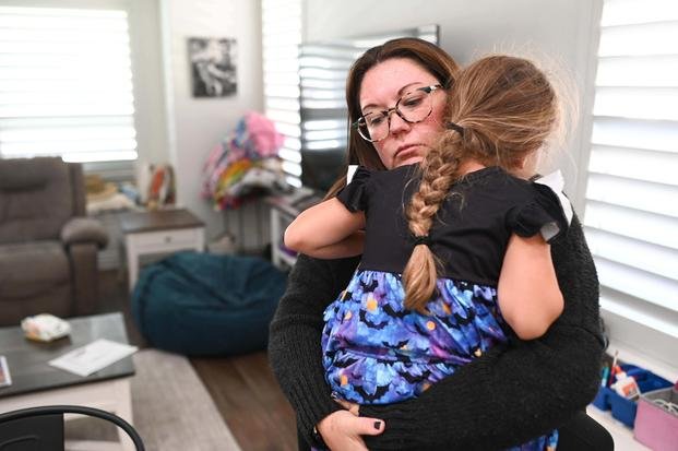 Jennifer Bittner holds her 6-year-old daughter Amelia at their home on Wednesday, Oct. 29, 2025, in Pflugerville, Texas. (AP Photo/Jack Myer) Government Shutdown Military Pay