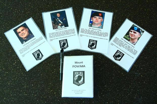Photo cards at the peak of Mount POW/MIA near Anchorage, Alaska honor several soldiers who have been award the POW Medal (Photo: courtesy of Kirk Alkire)