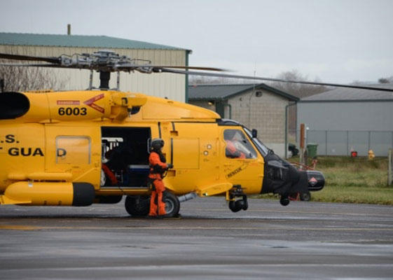A Coast Guard MH-60 Jayhawk helicopter with a special yellow paint scheme lands at Coast Guard Air Station Astoria, Ore., Jan. 15, 2016. (Coast Guard/Jonathan Klingenberg)