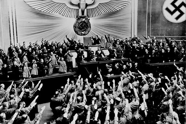 Adolf Hitler accepts the ovation of the Reichstag after announcing the “peaceful” acquisition of Austria in  March 1938. (National Archives photo)