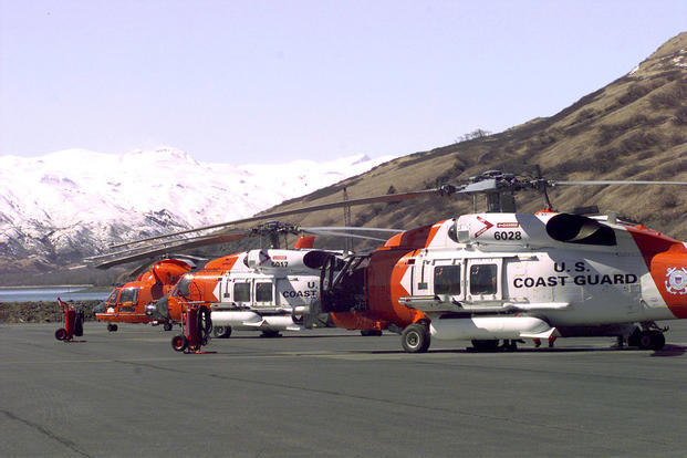 Two Coast Guard HH-60J helicopters and one HH-65A helicopter sit on the tarmac of Air Station Kodiak awaiting the next call for help. (U.S. Coast Guard photo by PAC Tod A. Lyons, USCG)