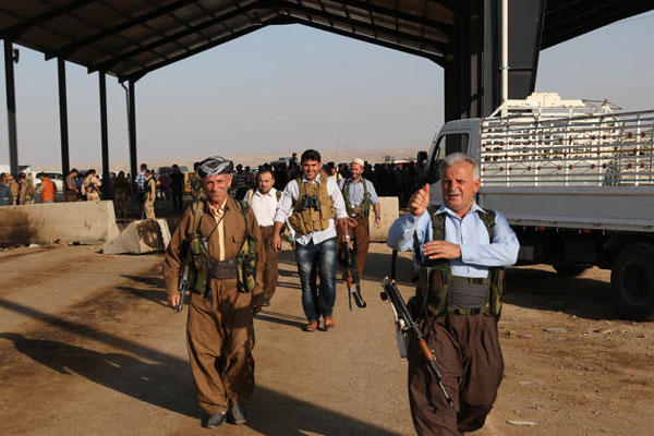Kurdish Peshmerga fighters walk toward the front line with militants from the extremist Islamic State group, at the Khazer checkpoint outside of the city of Irbil in northern Iraq, Friday, Aug. 8, 2014 (AP Photo/Khalid Mohammed)