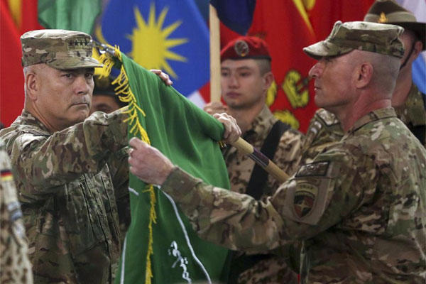 Commander of ISAF, Gen. John Campbell, left, and Command Sgt. Maj. Delbert Byers open the "Resolute Support" flag during a ceremony at the ISAF headquarters in Kabul, Sunday, Dec. 28, 2014. (AP Photo/Massoud Hossaini)