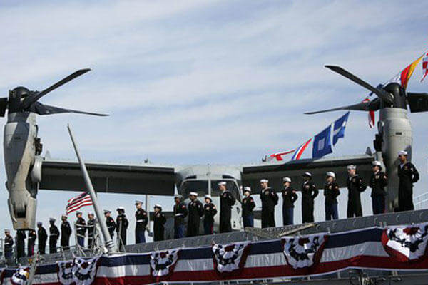 Crew members line the rails during a commissioning ceremony for the USS Somerset.