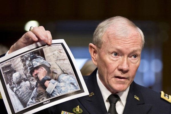 Gen. Martin Dempsey, chairman of the Joint Chiefs of Staff, holds up a photo of a deployed American soldier as he testifies before the Senate Armed Services Committee at his reappointment hearing, on Capitol Hill in Washington, Thursday, July 18, 2013.