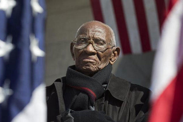 Richard Overton the oldest living WWII veteran, listens during a Veterans Day ceremony attended by President Barack Obama, commemorating Veterans Day, Monday, Nov. 11, 2013, at Arlington National Cemetery.