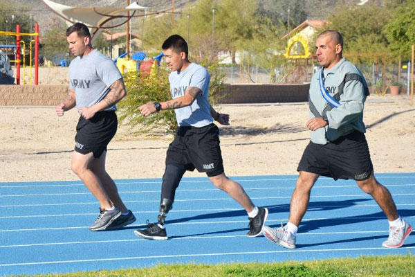 Spc. Kevin Nguyen performs an Army Physical Fitness Test at Fort Irwin, March 12. Staff Sgt. Rafael Machuca (right) of the 11th Armored Cavalry Regiment, here, administered the APFT. Sgt.1st Class Robert Peredo, left, is Nguyen's platoon sergeant.