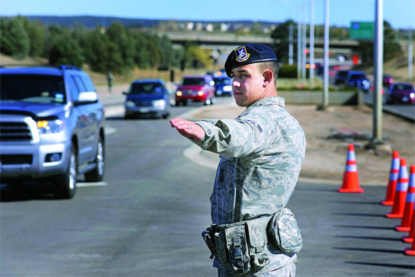 A 10th Security Forces Squadron Airman directs traffic through the Academy's north gate to Falcon Stadium for the Air Force vs. Notre Dame football game Oct. 26, 2013. (Air Force photo)