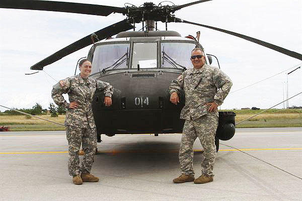 New York Army National Guard members Warrant Officer Meghan Polis, left, and Chief Warrant Officer 3 Stephen Polis pose in front of a UH-60 Black Hawk helicopter at Fort Drum, New York, July 22, 2015. (U.S. Army photo by Sgt. Jonathan Monfiletto)