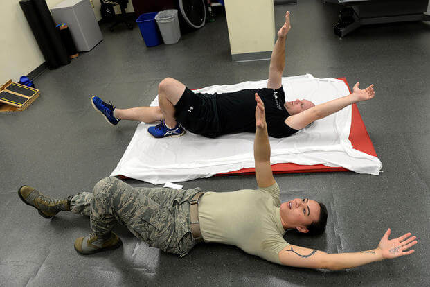 Staff Sgt. Amber Coley, a physical therapy technician, demonstrates an exercise for Tech. Sgt. Jared Rhynehart during a rehabilitation session, Nov. 18, 2015, at Seymour Johnson Air Force Base, N.C. (Photo: Airman 1st Class Ashley Williamson)