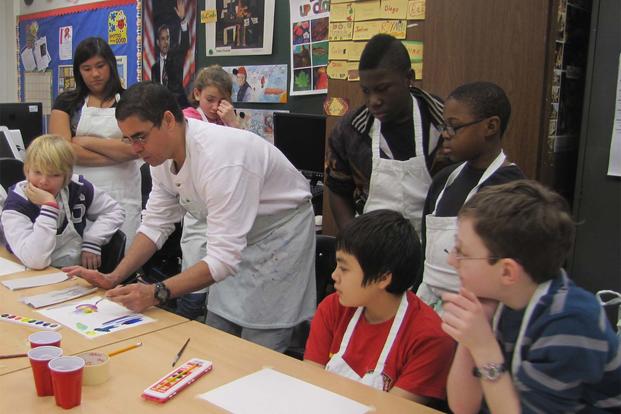 Artist Edward Codina leads the Heidelberg Middle School sixth-grade class in a watercolor techniques lesson as part of the worldwide 2012 U.S. Army Family and Morale, Welfare and Recreation Arts and Crafts. (Photo Credit: Heidelberg Middle School)