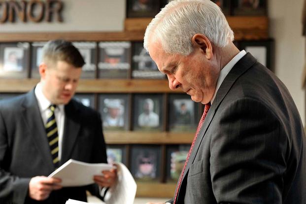 U.S. Defense Secretary Robert M. Gates, right, and Ryan McCarthy, the secretary's special assistant, look over paperwork while visiting Camp Eggers in Kabul, Dec. 8, 2009. (DoD Photo)