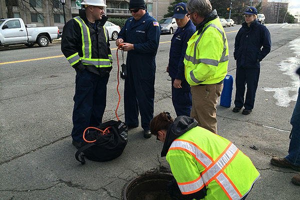 Members of the Coast Guard Atlantic Area Strike Team and the Arlington Department of Environmental Services inspect manholes near South Fern Street in Arlington, Va., Monday, Feb. 8, 2016. (US Coast Guard/PO2 David Marin)