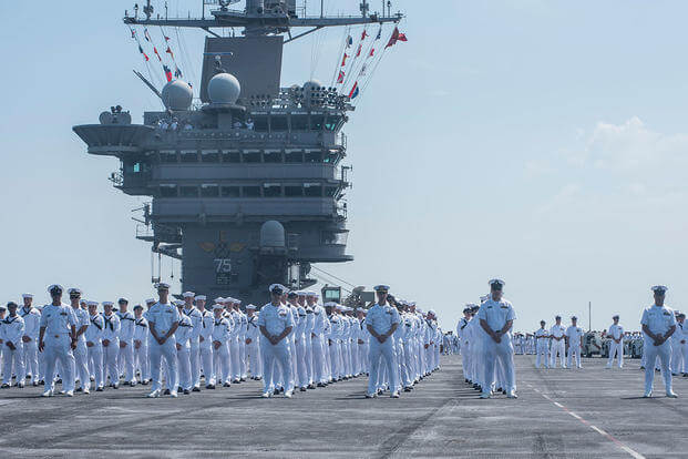 Sailors prepare to man the rails aboard the aircraft carrier USS Harry S. Truman (CVN 75) as it returns to homeport at Naval Station Norfolk, completing an 8-month deployment. (U.S. Navy/MC3 Adelola Tinubu/Released)