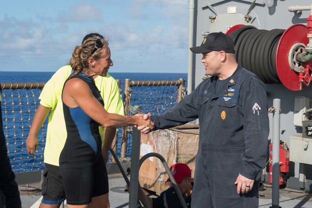 USS Ashland Command Master Chief Gary Wise welcomes aboard Jennifer Appel, an American mariner who had received assistance from Ashland crew members. (U.S. Navy/Mass Communication Specialist 3rd Class Jonathan Clay)