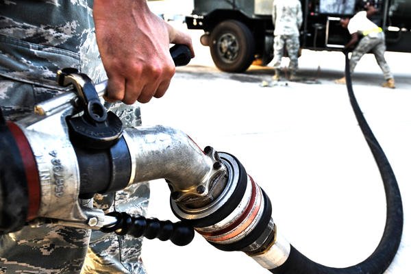 Servicemembers connect a fuel line.