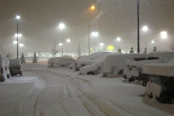 Snow covering cars in piles.