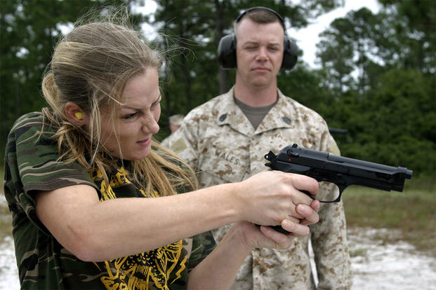 Caption: A Marine spouse shoots a target with a M9 9mm pistol. (U.S. Marine Corps)