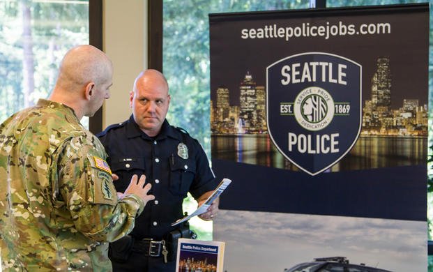 A Joint Base Lewis-McChord soldier speaks with a Seattle Police Department recruiter at a networking and hiring event at the American Lake Conference Center, May 11. (Photo by Staff Sgt. Bryan Dominique)