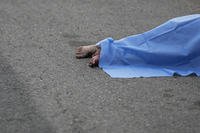 A blue sheet covers a body found lying on the side of a road in Culiacan, Sinaloa state, Mexico