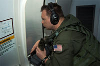 Chief Naval Aircrewman (Operator) Samuel Judd, assigned to Patrol Squadron (VP) 16, searches out the window of a P-8A Poseidon while flying over the Indian Ocean in support of the international effort to locate Malaysia Airlines flight MH370.