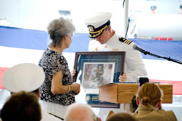 Dolia Gonzalez, mother of Sgt. Alfredo "Freddy" Gonzalez, receives a portrait of her son during a change-of-command ceremony for the USS Gonzalez. (DoD photo)