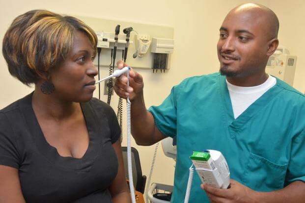 A medical assistant checks a patient’s temperature during a hospital visit. (U.S. Navy/Jacob Sippel) 