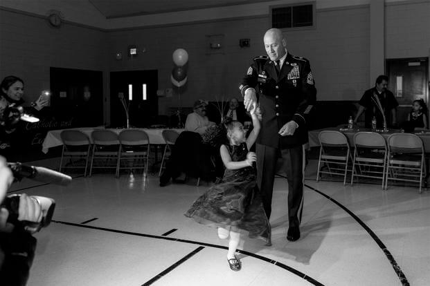 Cayleigh Hinton, daughter of Sgt. Terrence Hinton, dances with 1st Sgt. Joseph Bierbrodt at a father-daughter dance in Illinois. Cayleigh's father, Sgt. Terrence Hinton, died in a training accident May 14, 2017 in Hawaii. (Illinois National Guard/Staff Sgt. Robert R. Adams)