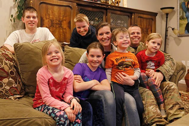 Maj. Patrick Vankirk sits with his wife Theresa, and their six children near Fort Drum, New York (U.S. Army/Paige Behringer)