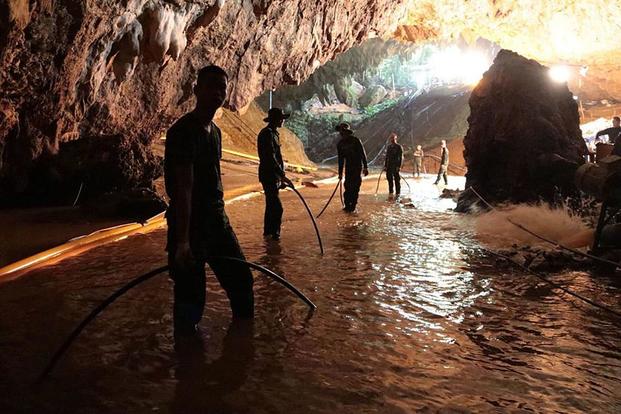 Thai rescue teams arrange a water pumping system at the entrance to a flooded cave complex where 12 boys and their soccer coach were trapped in northern Thailand. (Royal Thai Navy photo)