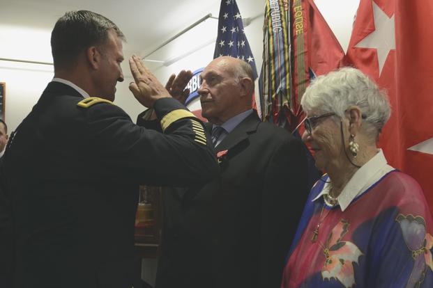William Gaschler, a retired Army veteran, accompanied by his wife, Karla Gaschler, exchanges a salute with Maj. Gen. Michael E. Kurilla during a Bronze Star Medal with Valor award presentation on Fort Bragg, N.C., July 28, 2018. (U.S. Army/Staff Sgt. Elvis Umanzor)