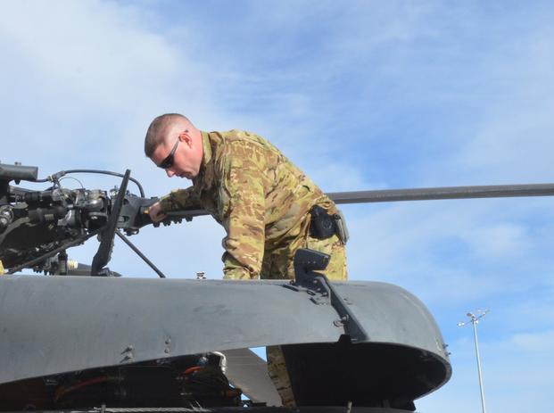 Conducting pre-flight checks, then-Chief Warrant Officer 2 Taylor Galvin, a pilot with Company C, 2nd General Support Aviation Battalion, 1st Aviation Regiment, observes the hydraulic deck of a UH-60 Black Hawk helicopter, Jan. 15, 2014, at Kandahar Airfield, Afghanistan. Galvin was killed when his MH-60 Black Hawk crashed in Iraq Aug. 20 (Andrew Cochran/U.S. Army)