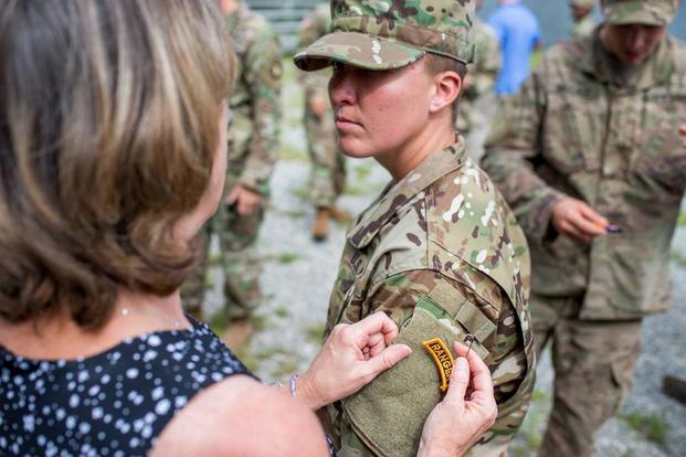 Staff Sgt. Amanda F. Kelley's family member pins on her Ranger tab during a graduation ceremony for Ranger Class 08-18 at Fort Benning, Ga., Aug. 31, 2018. (U.S. Army/Patrick A. Albright)