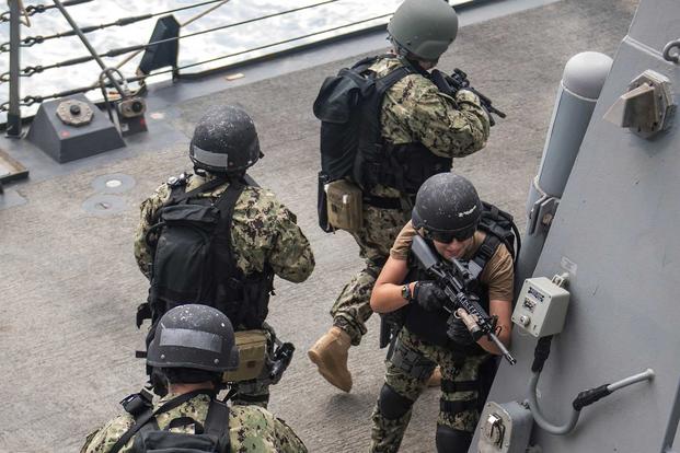 Lt. j.g. Elizabeth Warner sets security for sailors to maneuver on the boat deck of the guided-missile destroyer USS Jason Dunham (DDG 109) during a visit, board, search and seizure training evolution Aug. 23, 2018, in the 5th Fleet Area of Operations. (U.S. Navy photo by Mass Communication Specialist 3rd Class Jonathan Clay)
