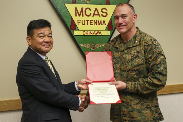 Japan- Police Chief Osamu Hamada, left, accepts a letter of appreciation from Col. Mark Coppess during an award ceremony March 8 on Marine Corps Air Station Futenma, Okinawa, Japan. (U.S. Marine Corps/Pfc. Nicole Rogge)