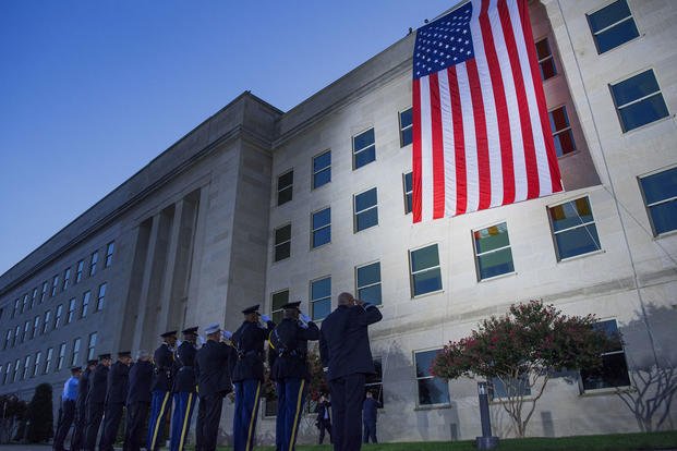 First Responders salueren een grote Amerikaanse vlag die zich ontvouwt over de westkant van het Pentagon bij zonsopgang in Washington, D. C., Sept. 11, 2017. Tijdens de Sept. 11, 2001, aanslagen, 184 mensen werden gedood in het Pentagon. (Dominique A. Pineiro / U. S. Navy)'s unfurled over the west side of the Pentagon at sunrise in Washington, D.C., Sept. 11, 2017. During the Sept. 11, 2001, attacks, 184 people were killed at the Pentagon. (Dominique A. Pineiro/U.S. Navy)