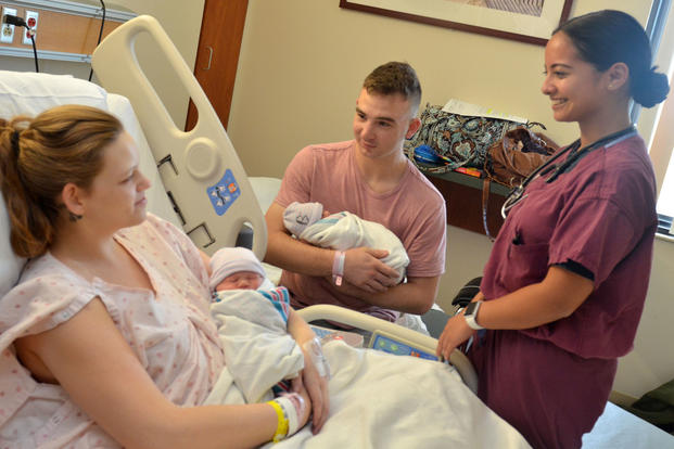 Ensign Michelle Araya, a registered nurse, checks on Marine Cpl. Nicholas Digregorio and wife Danielle as they hold their newborn twin girls at Naval Hospital Jacksonville, Sept. 14, 2018. The Digregorio family, originally from St. Augustine, Florida, is stationed at Marine Corps Base Camp Lejeune in North Carolina and evacuated due to Hurricane Florence. (U.S. Navy photo/Jacob Sippel)